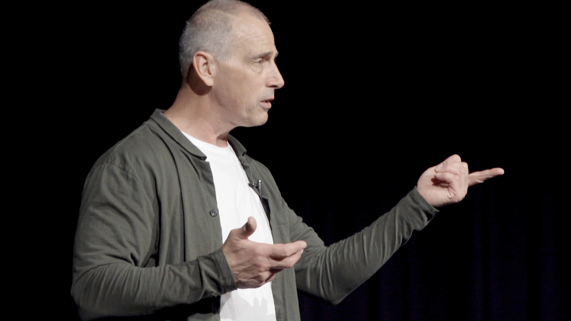 Jim Brayshaw gesturing on stage during a keynote